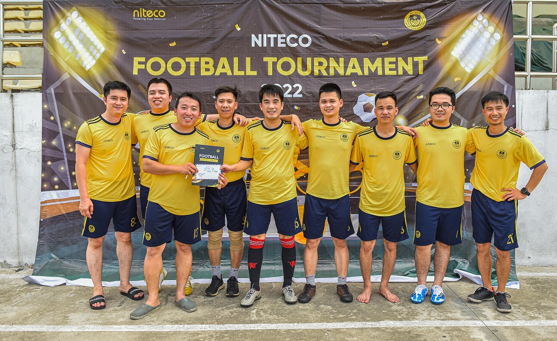 Niteco football tournament 2022 team in yellow jerseys posing with award