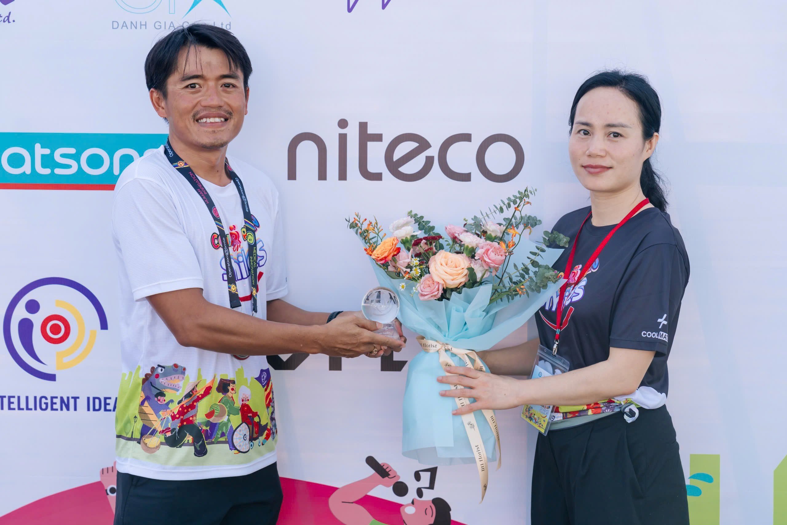 Niteco team holding cups for supporting cleft palate surgeries