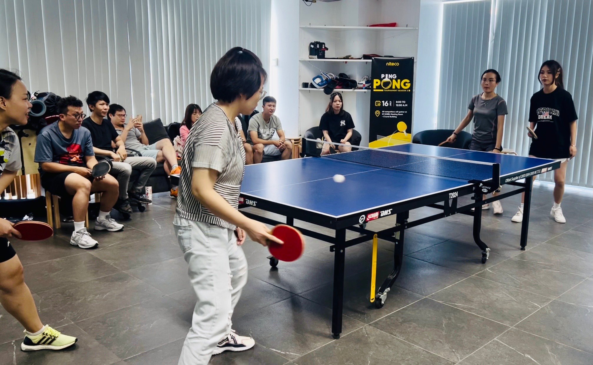 Office ping pong tournament with players and audience in a modern meeting room