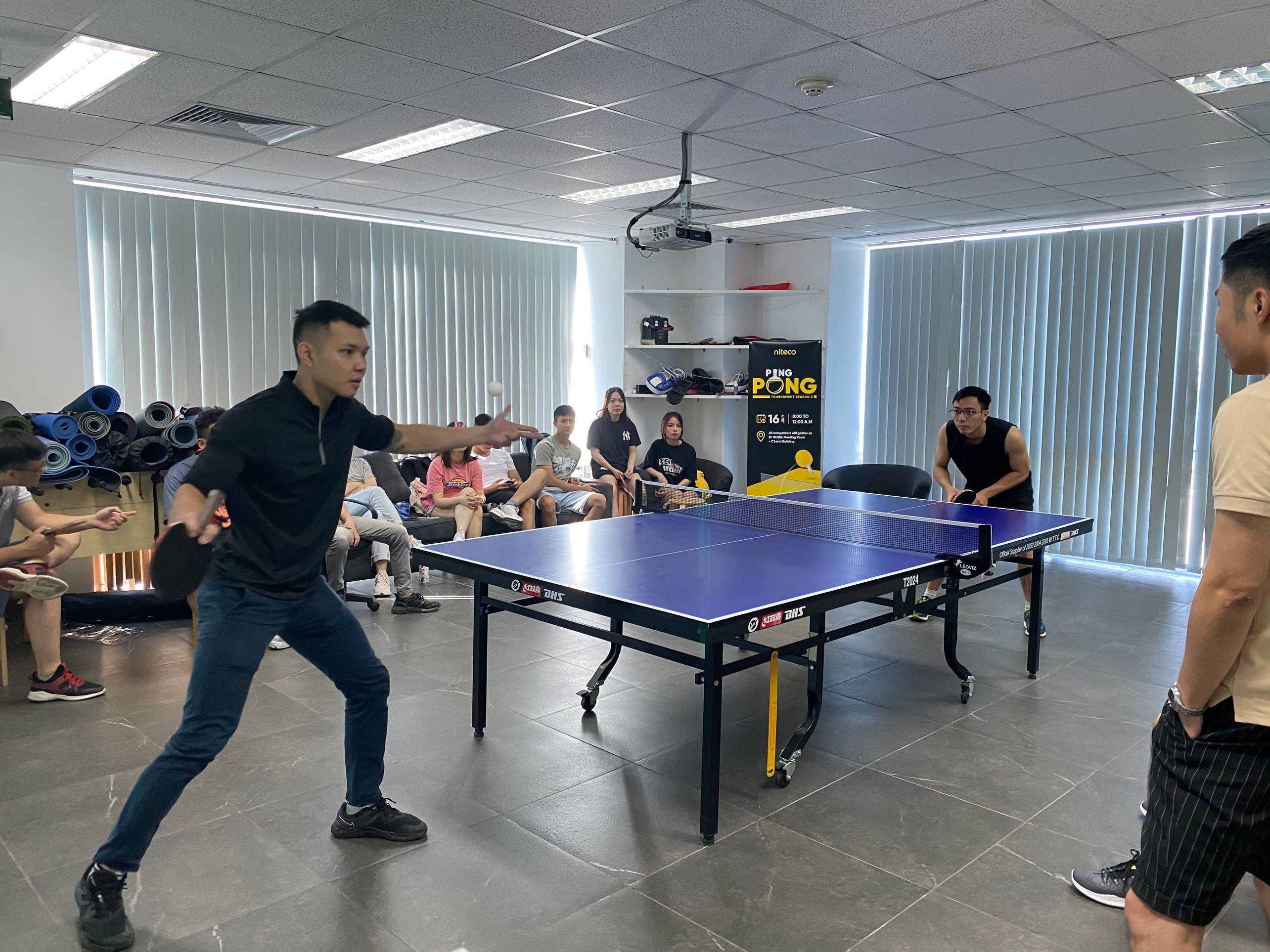 Ping pong tournament players competing intensely indoors with spectators watching