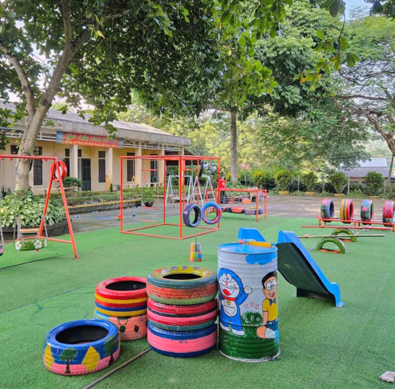 Colorful playground with swings, slide, and recycled tire toys on turf