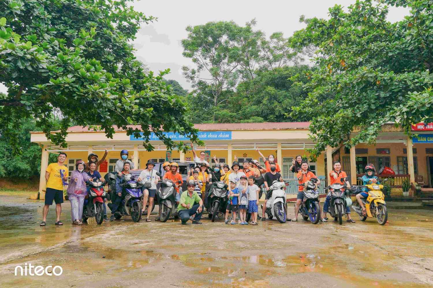Group of young people on motorcycles celebrating outdoors at Niteco event