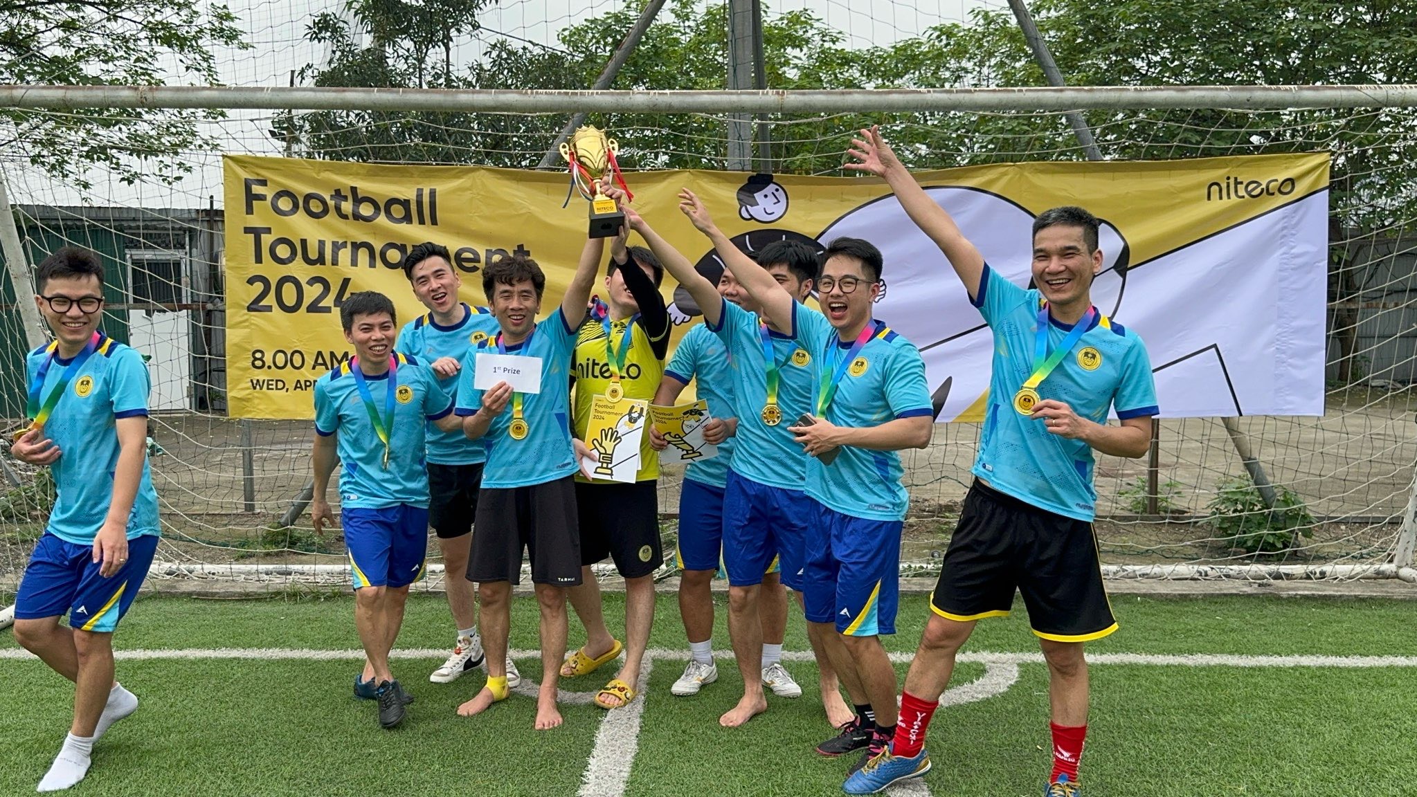 Football Tournament 2024 winners celebrating with trophy and medals on field