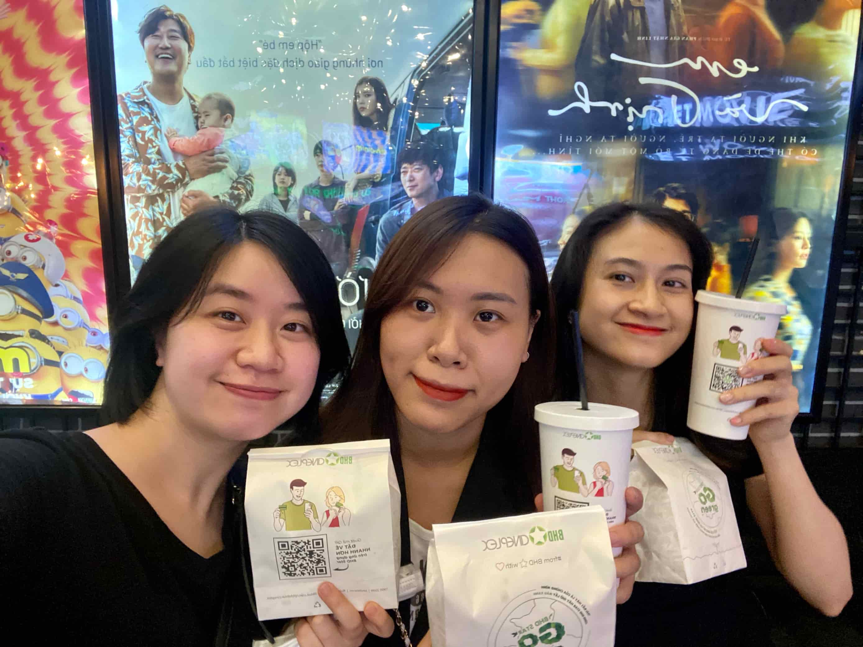 Three friends holding BHD Star movie snacks and drinks at cinema lobby