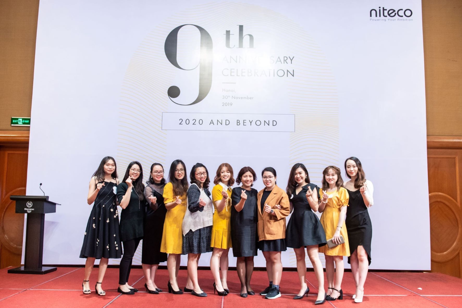 Niteco 9th anniversary celebration with staff posing on stage in Hanoi