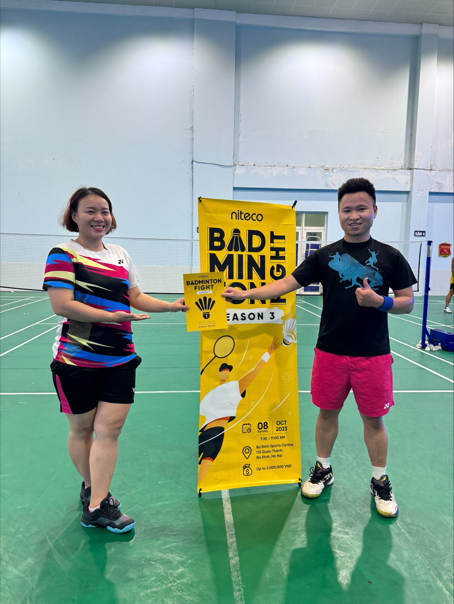 Two badminton players holding the Niteco Badminton Fight Season 3 first prize certificate