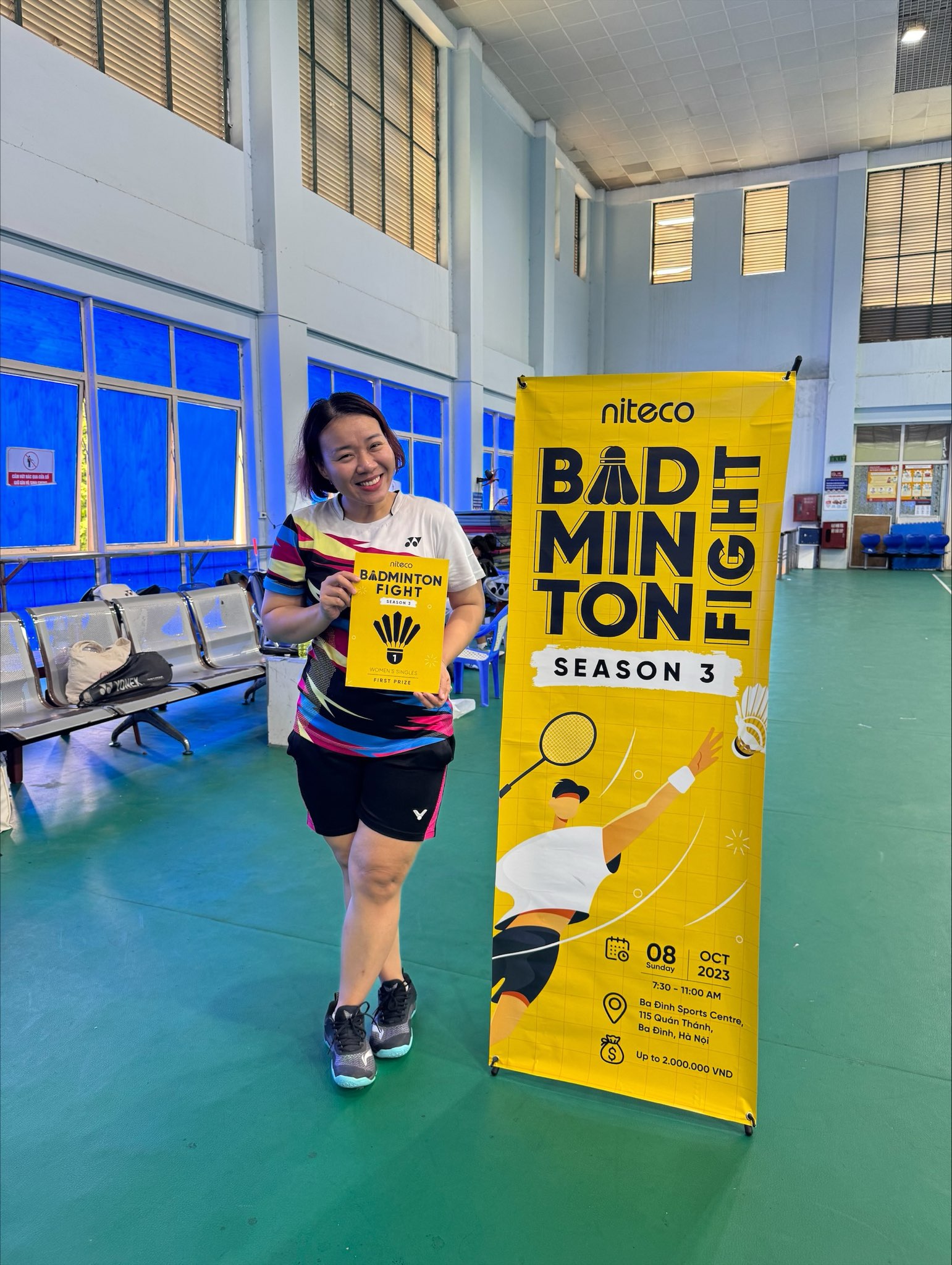Woman holding badminton fight season 3 first prize certificate at sports center