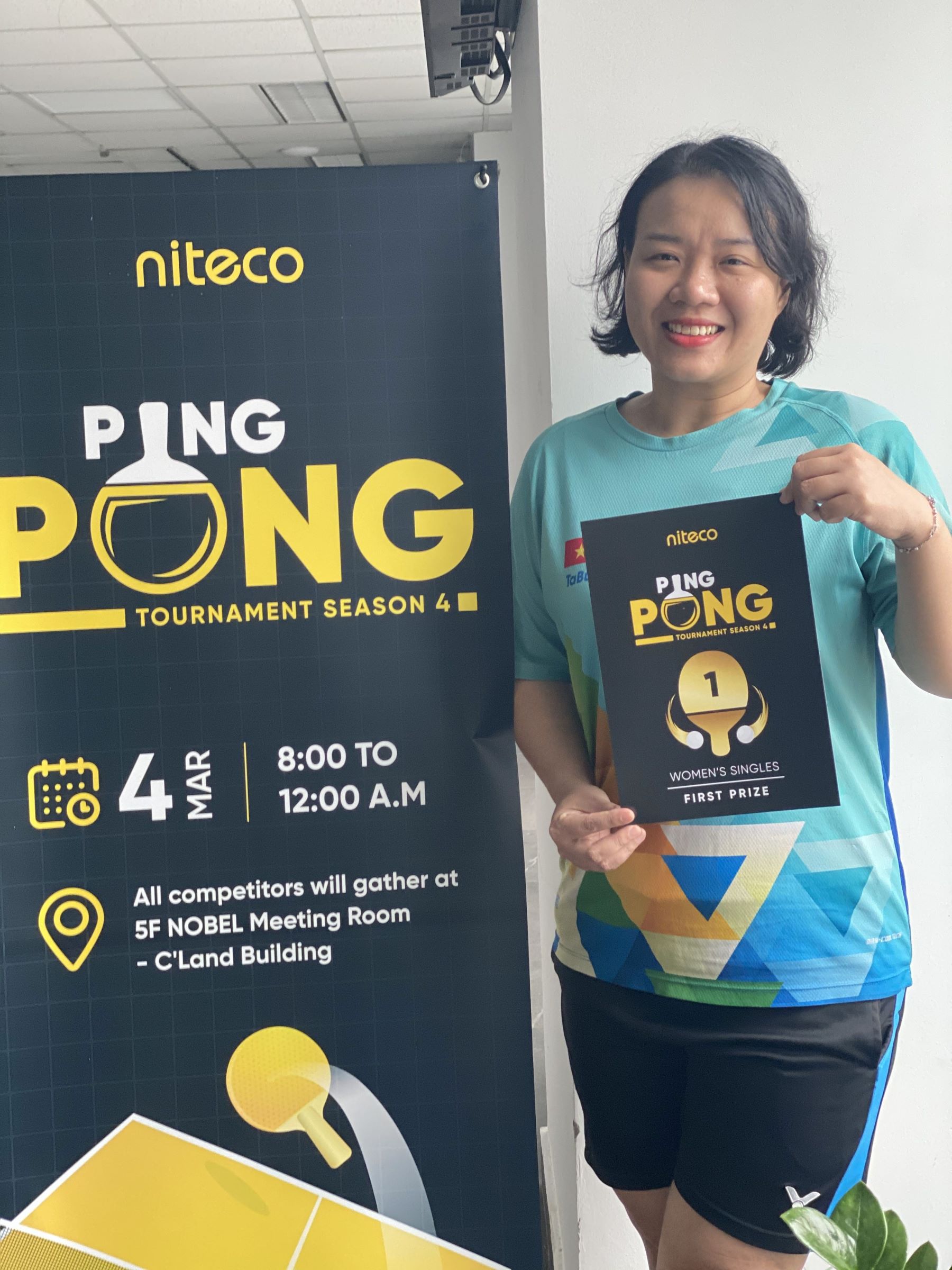 Winner of Niteco Ping Pong Tournament Season 4 Women's Singles holding first prize plaque