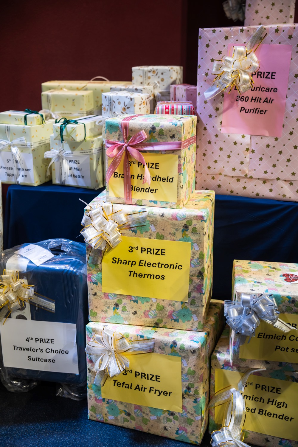Prizes wrapped for giveaway including air fryer, electronic thermos, and suitcase