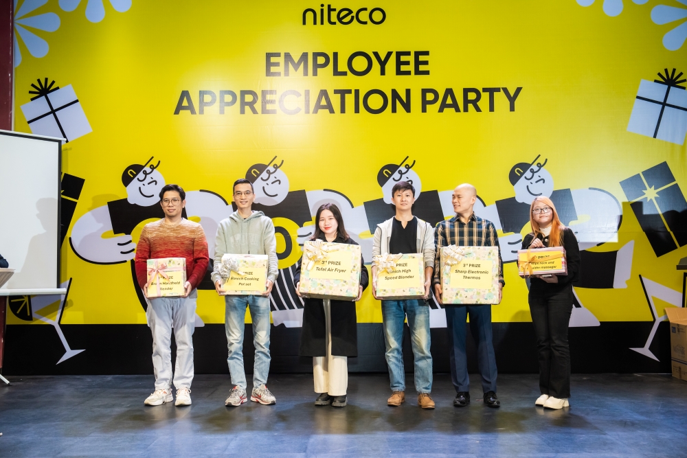 Niteco Employee Appreciation Party winners holding gift prizes on stage