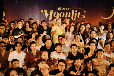Niteco Moonlit event group photo with diverse participants and crescent moon backdrop