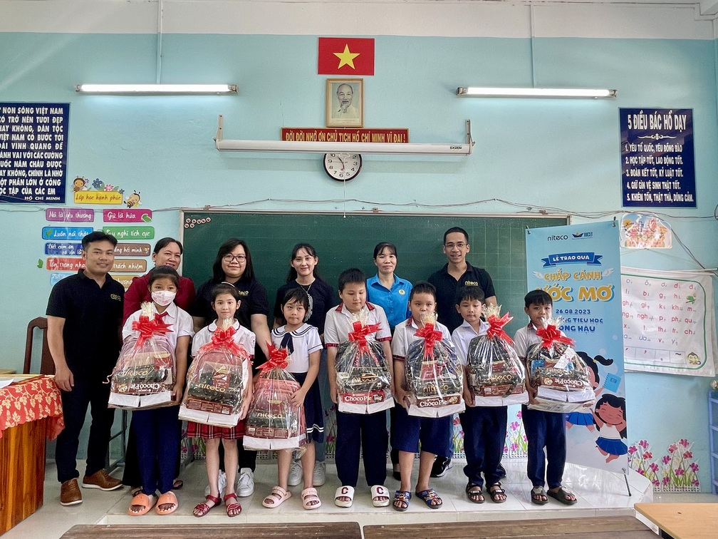 Students receiving gift baskets during the Chắp Cánh Ước Mơ event at school