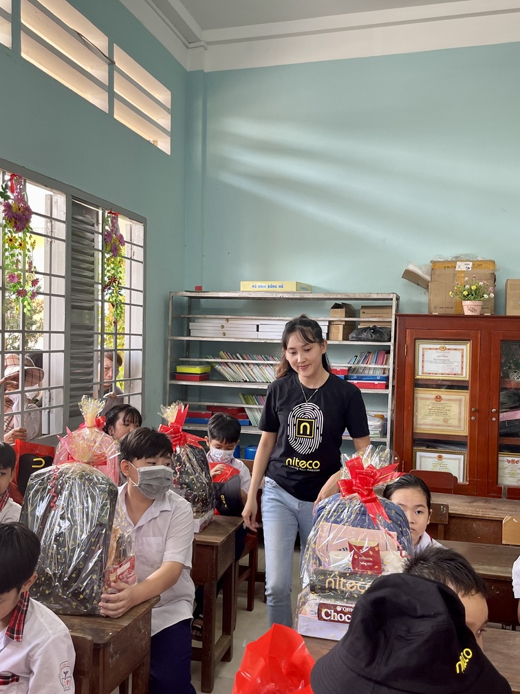 Students receiving gift packages in classroom during Niteco community event