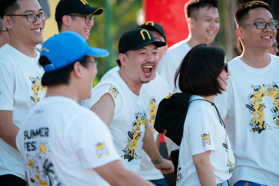 Group of young adults smiling and enjoying summer fest activities outdoors