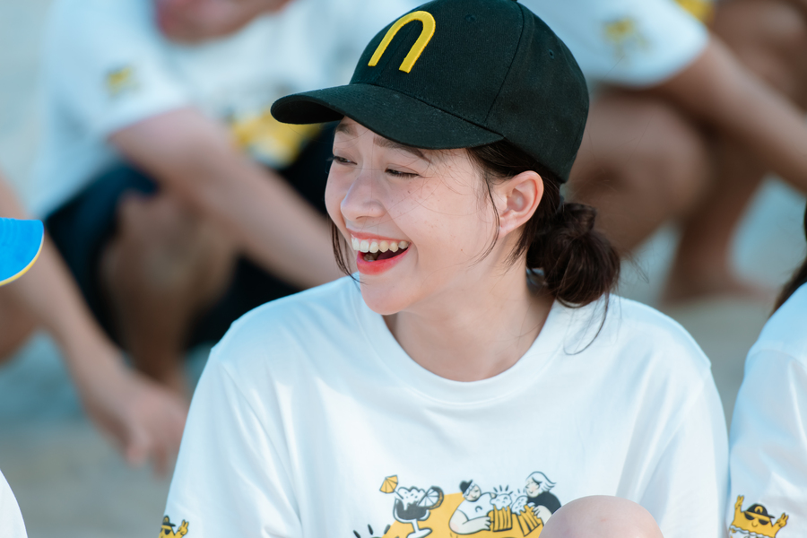 Smiling woman wearing black cap and white t-shirt at fun outdoor event