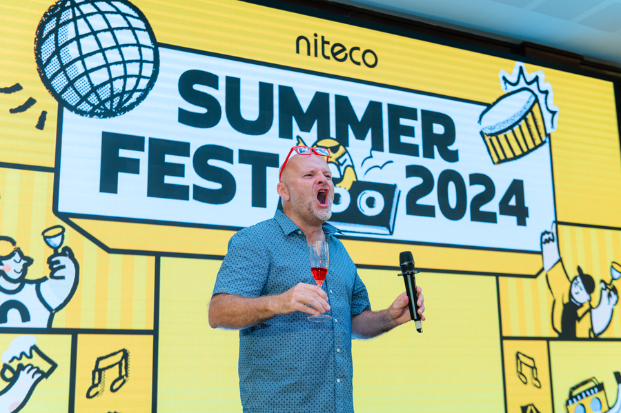 Man holding microphone and drink at Niteco Summer Fest 2024 stage