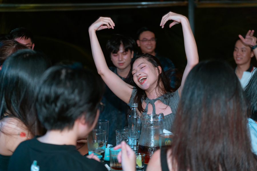 Young woman dancing joyfully at lively party with friends celebrating together