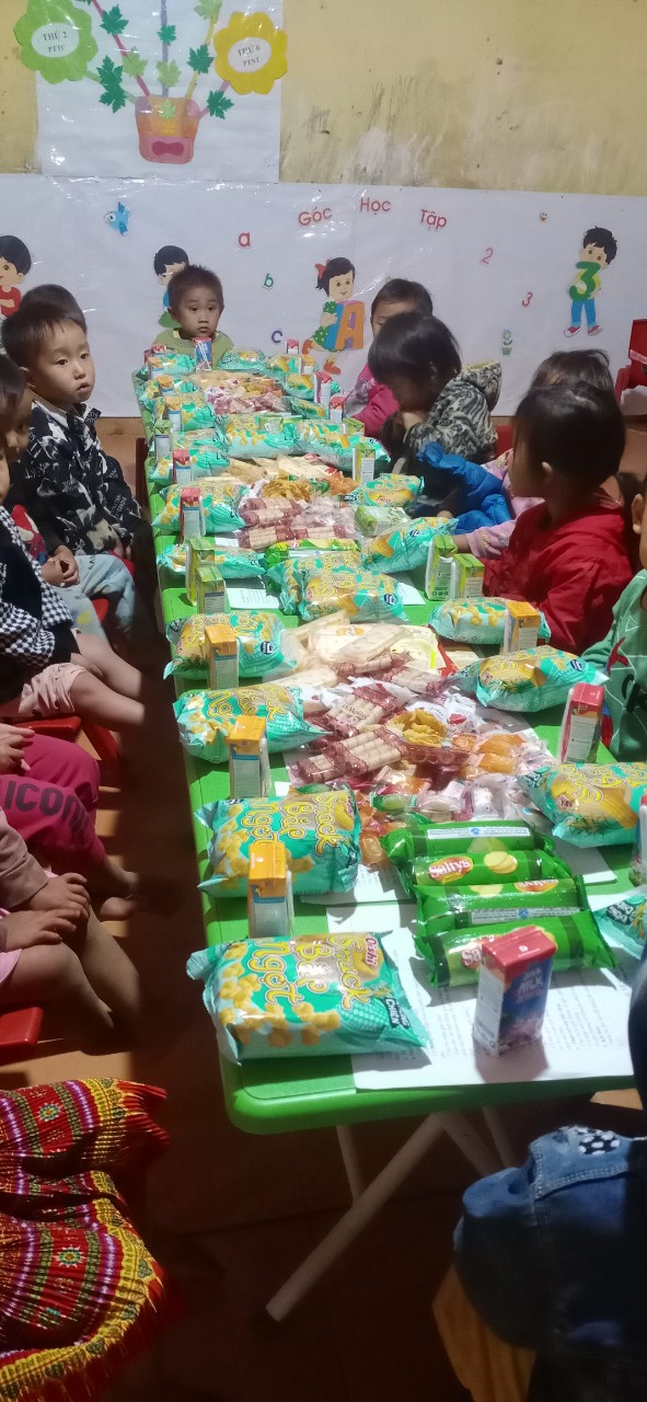 Children celebrating with snacks and drinks at a kindergarten party table