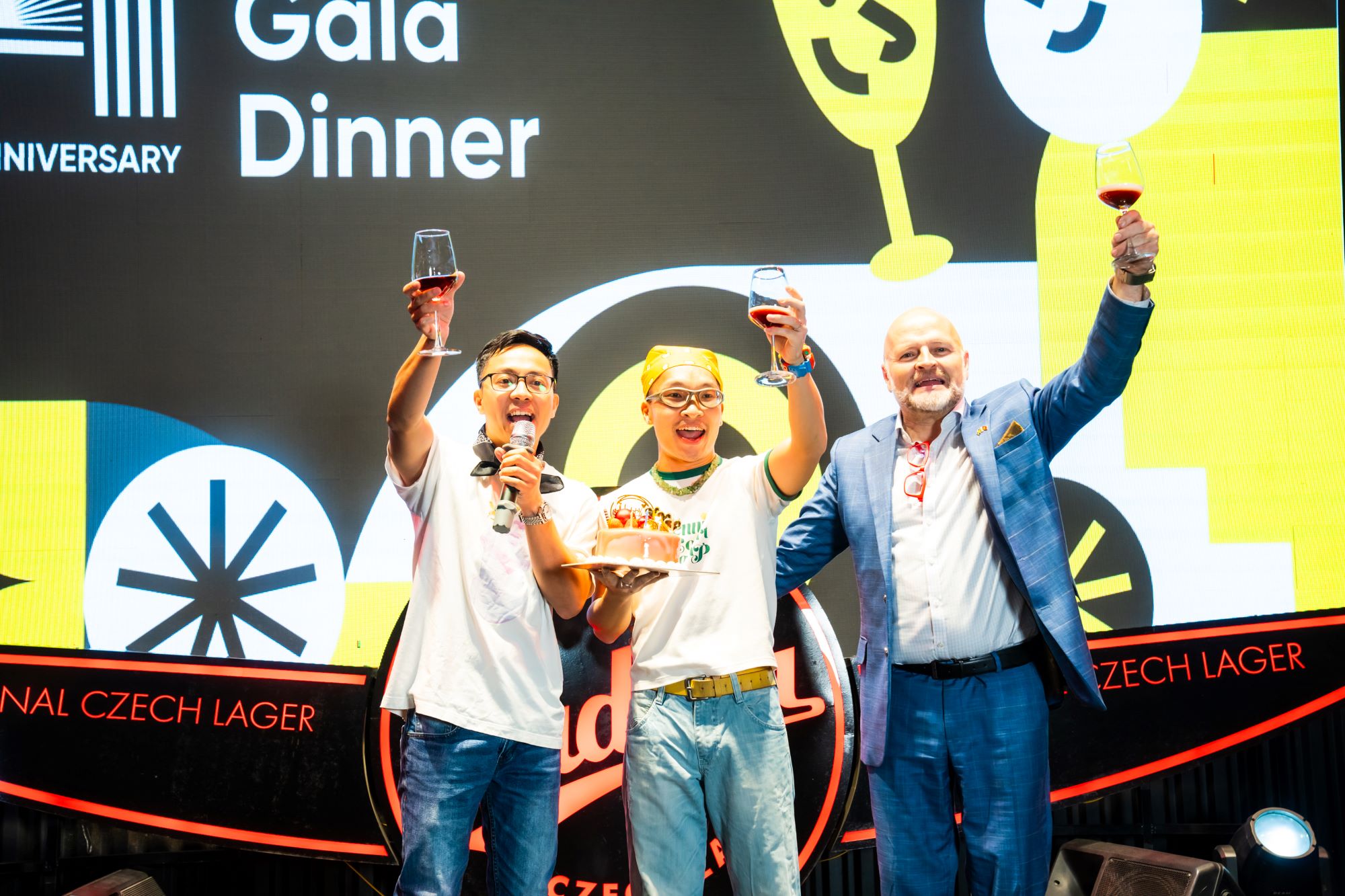 Three men raising wine glasses celebrating at Gala Dinner anniversary event