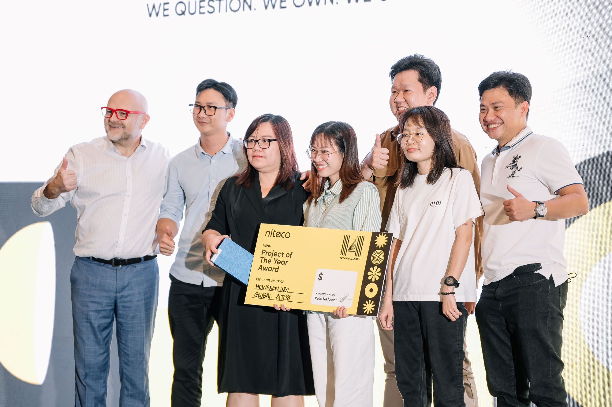 Team receiving Niteco Project of the Year Award holding large check with thumbs up