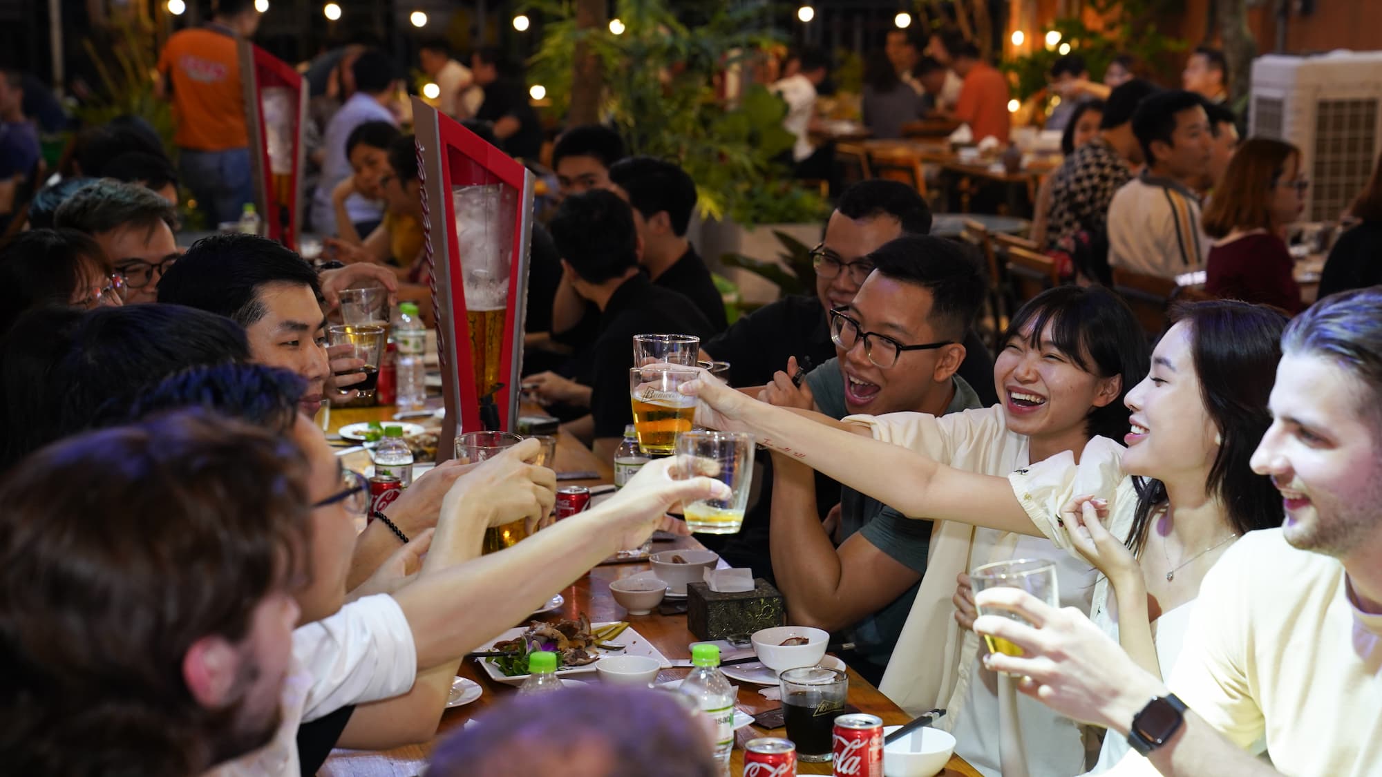 Friends enjoying Happy Hour with drinks and laughter at a lively restaurant