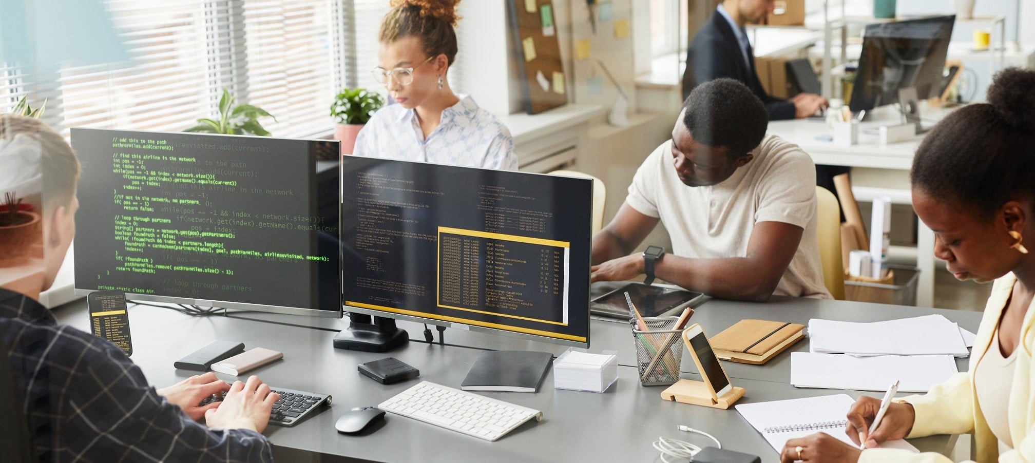 Team collaborating on software development and coding in modern office environment