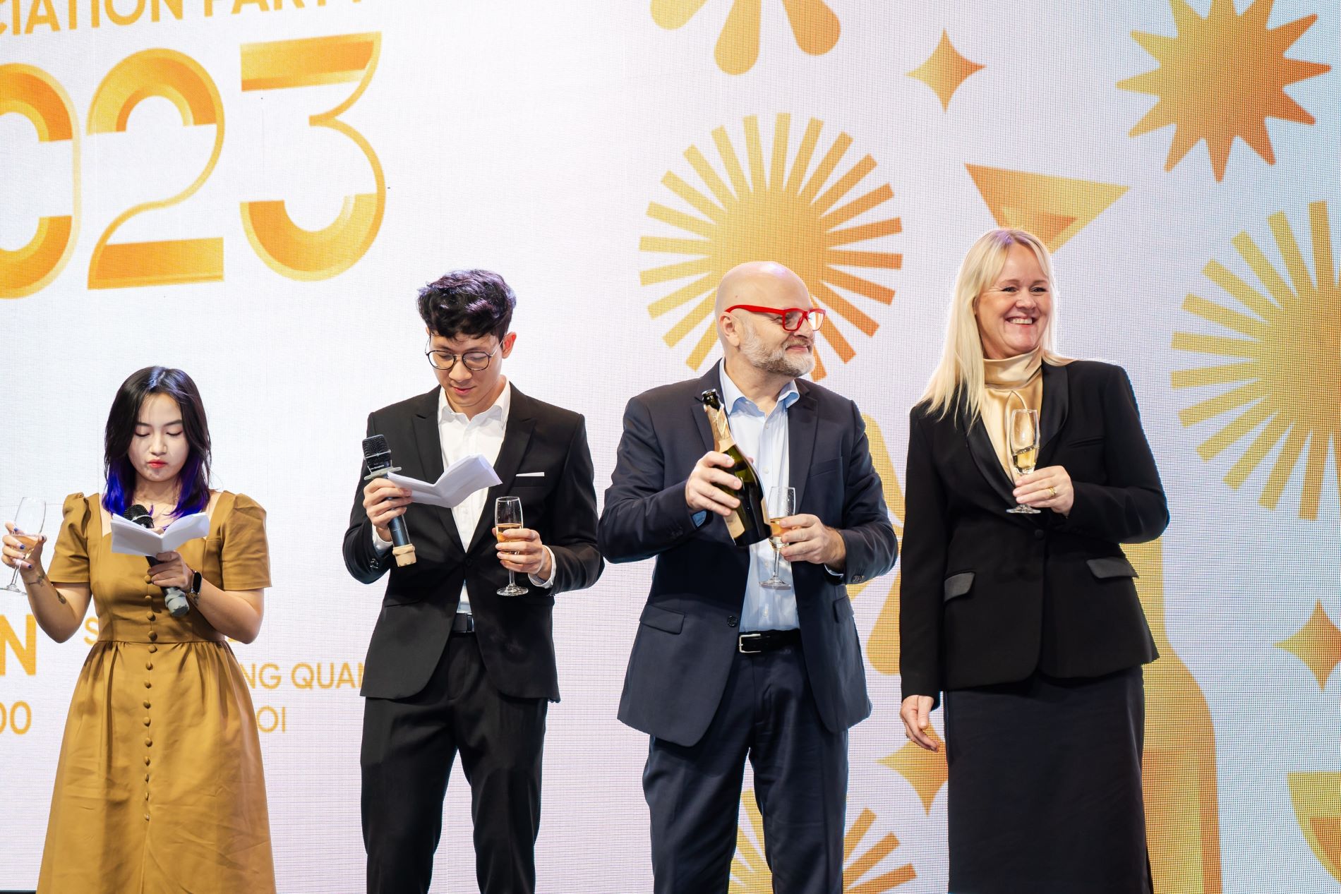Celebration party 2023 with speakers and champagne toast on stage