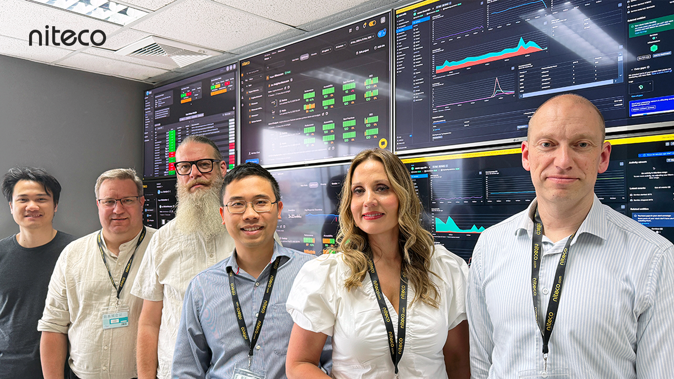 Niteco team members in front of data monitoring screens showing analytics and charts