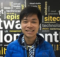 Smiling young man in blue jacket with technical keywords background