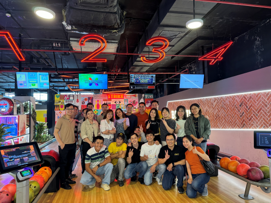 Group of friends enjoying bowling in a vibrant, neon-lit alley