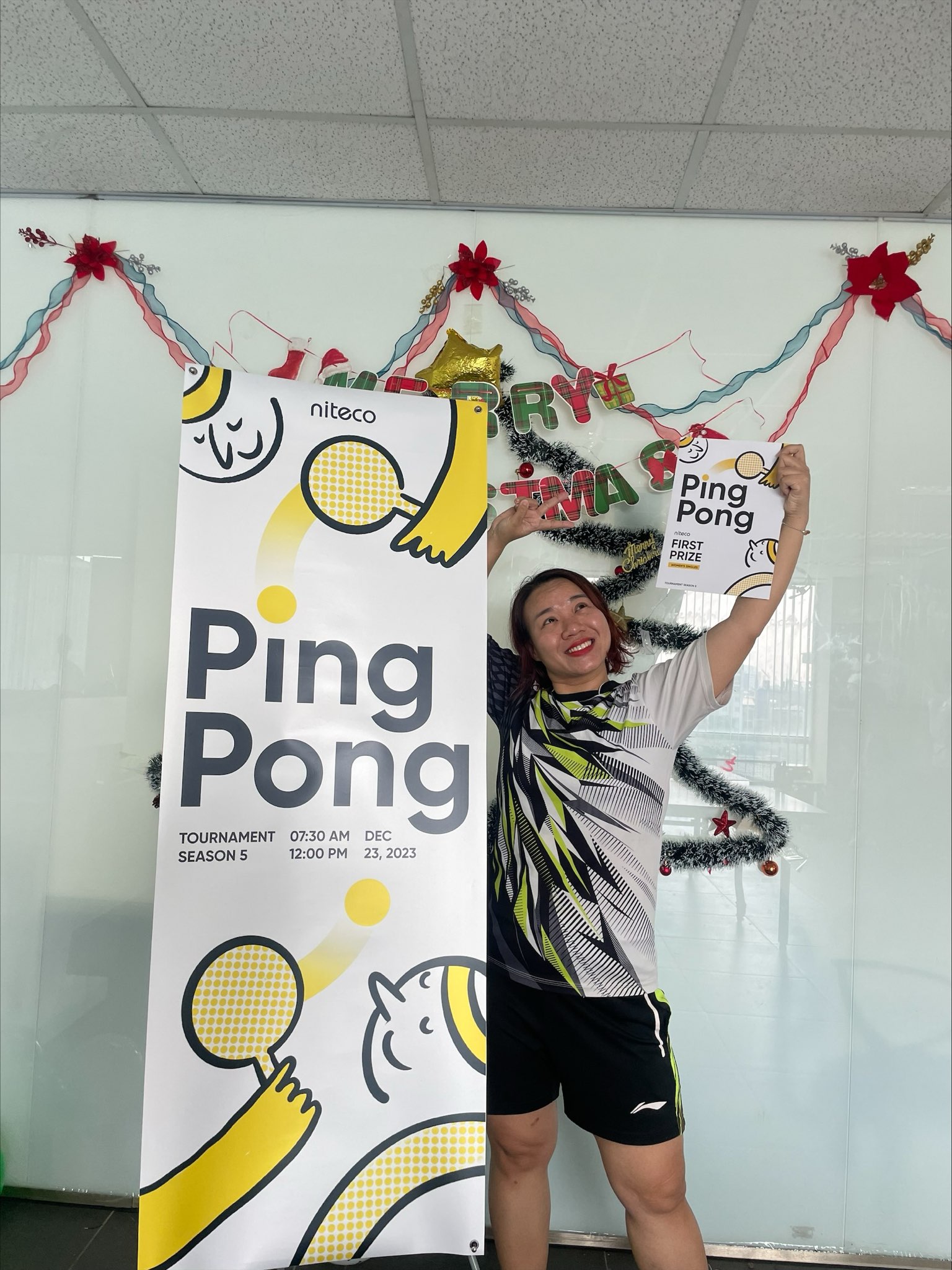 Woman celebrating Ping Pong tournament victory holding first prize certificate