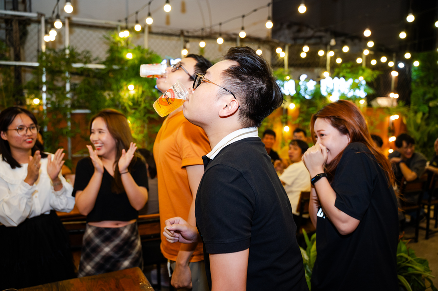 Young adults enjoying a vibrant party drinking beer and cheering at night