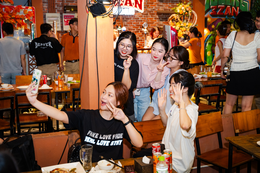 Friends enjoying casual dining and taking selfies at a lively restaurant