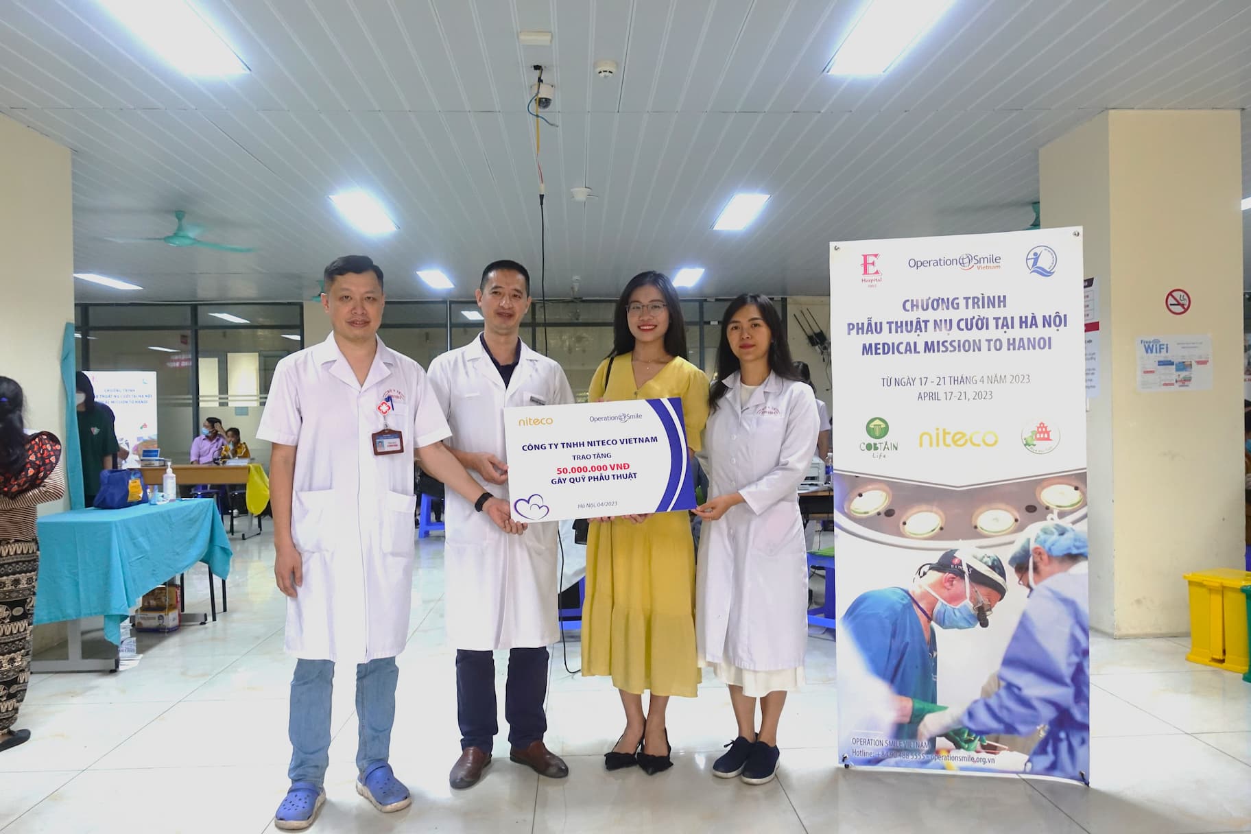 Medical mission to Hanoi team holding donation check for cleft surgery program