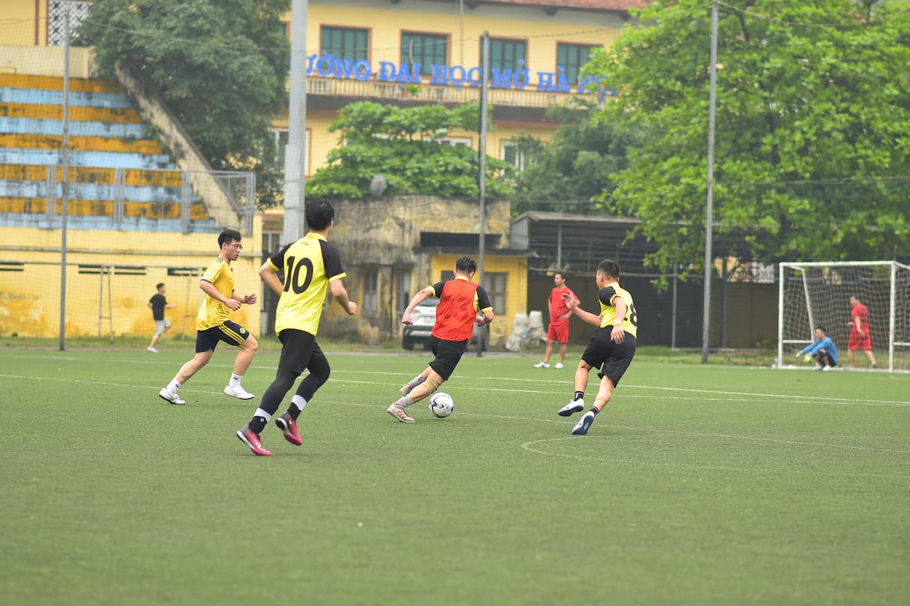 Soccer players in action on Hanoi Open University sports field during practice session