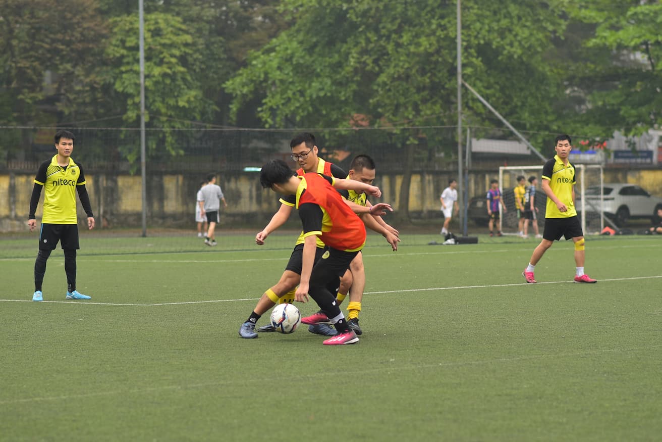 Young soccer players contesting the ball on a green football field