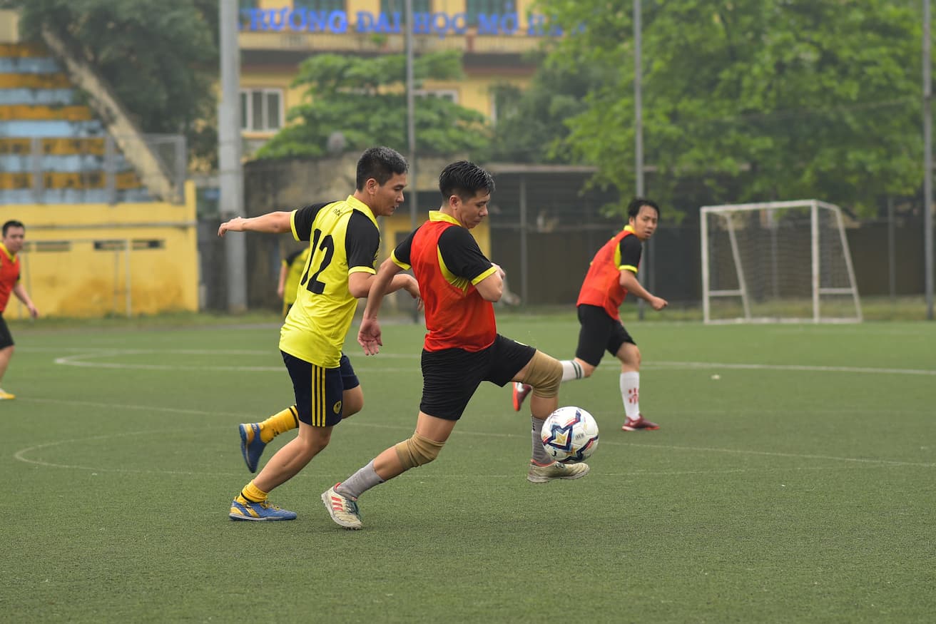 Soccer players competing for the ball on a green field during a match