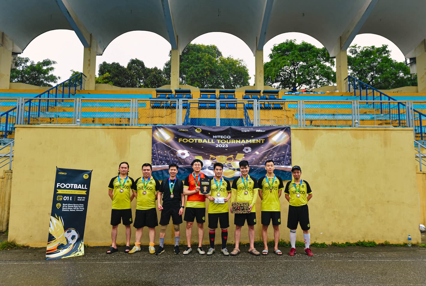 Niteco Football Tournament 2023 team wearing medals in front of stadium seating