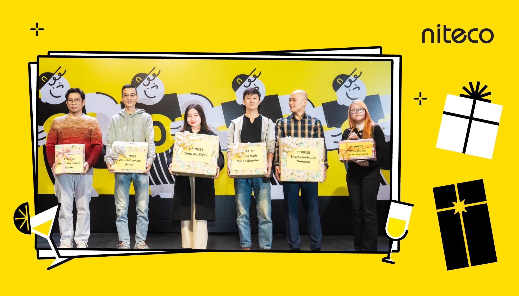 Winners holding prizes at Niteco event with branded yellow background and gifts