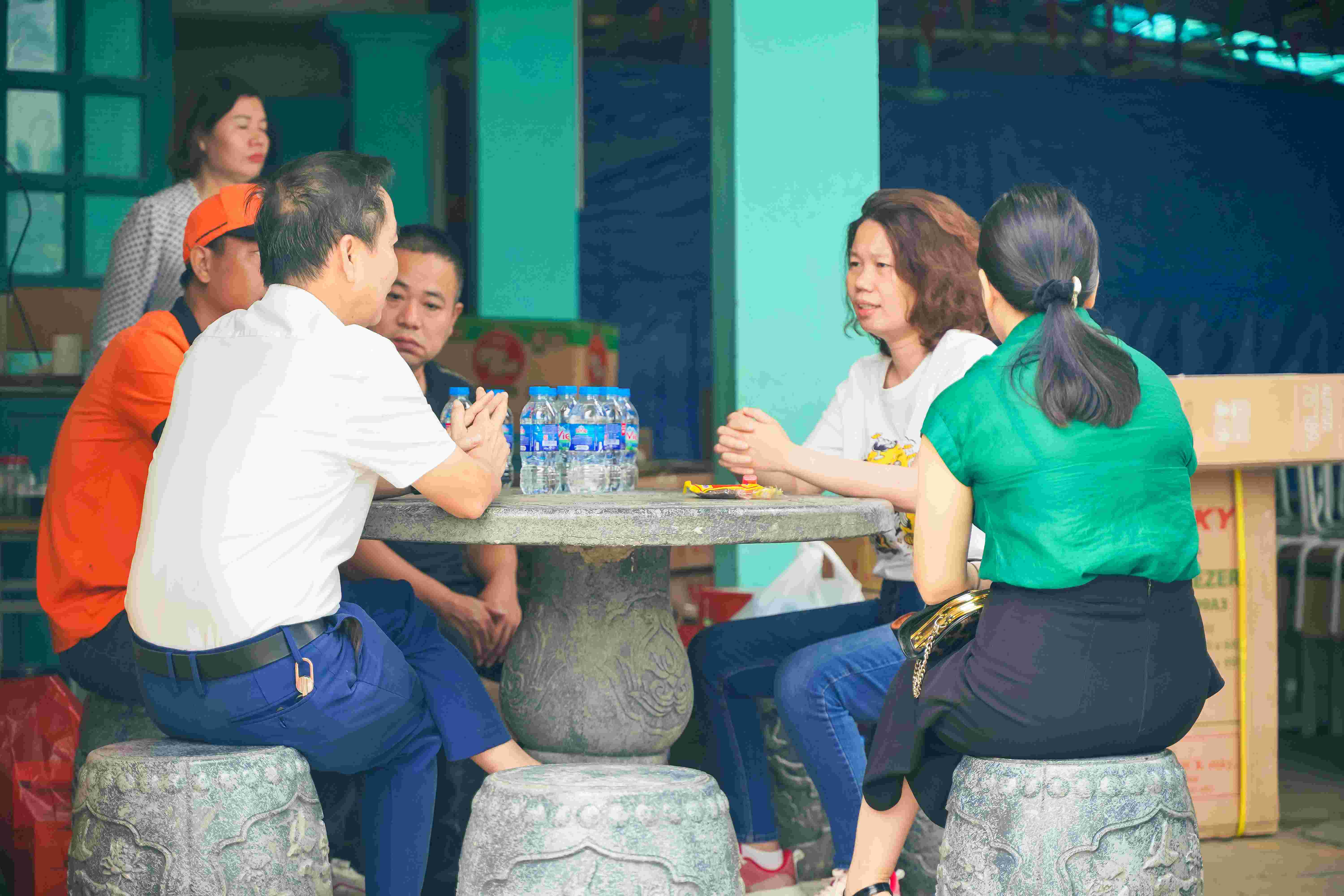 Group discussion around stone table during community meeting in Vietnam