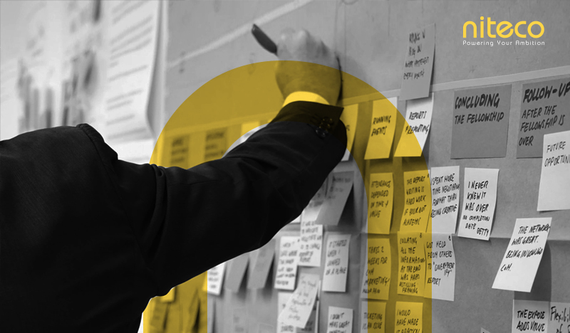 Person organizing sticky notes on a board during a Niteco project planning session