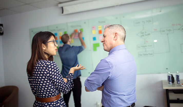 Team collaborating on project planning using sticky notes and workflow diagram