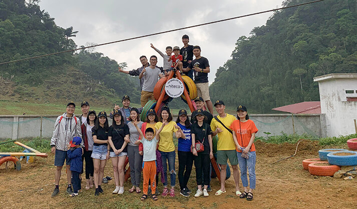 Group of Niteco employees and families at outdoor team-building event in nature