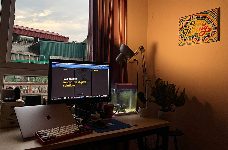 Home workspace with a monitor showing innovative digital solutions website at sunset