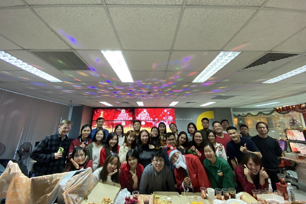 Office Christmas party with team members enjoying pizza and festive decor