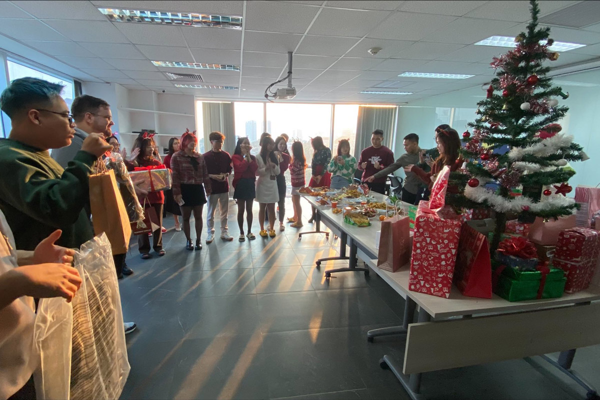 Office Christmas party with employees exchanging gifts and festive decorations