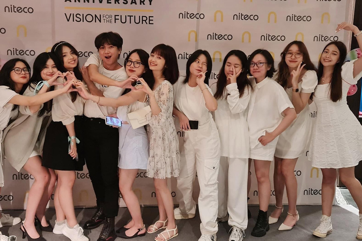 Niteco team celebrating anniversary with heart signs and smiles, vision for future