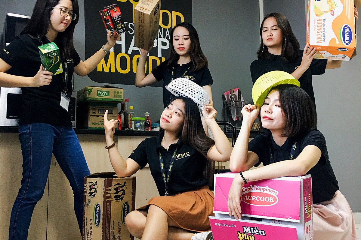 Five women in black niteco shirts holding food boxes and kitchen strainers