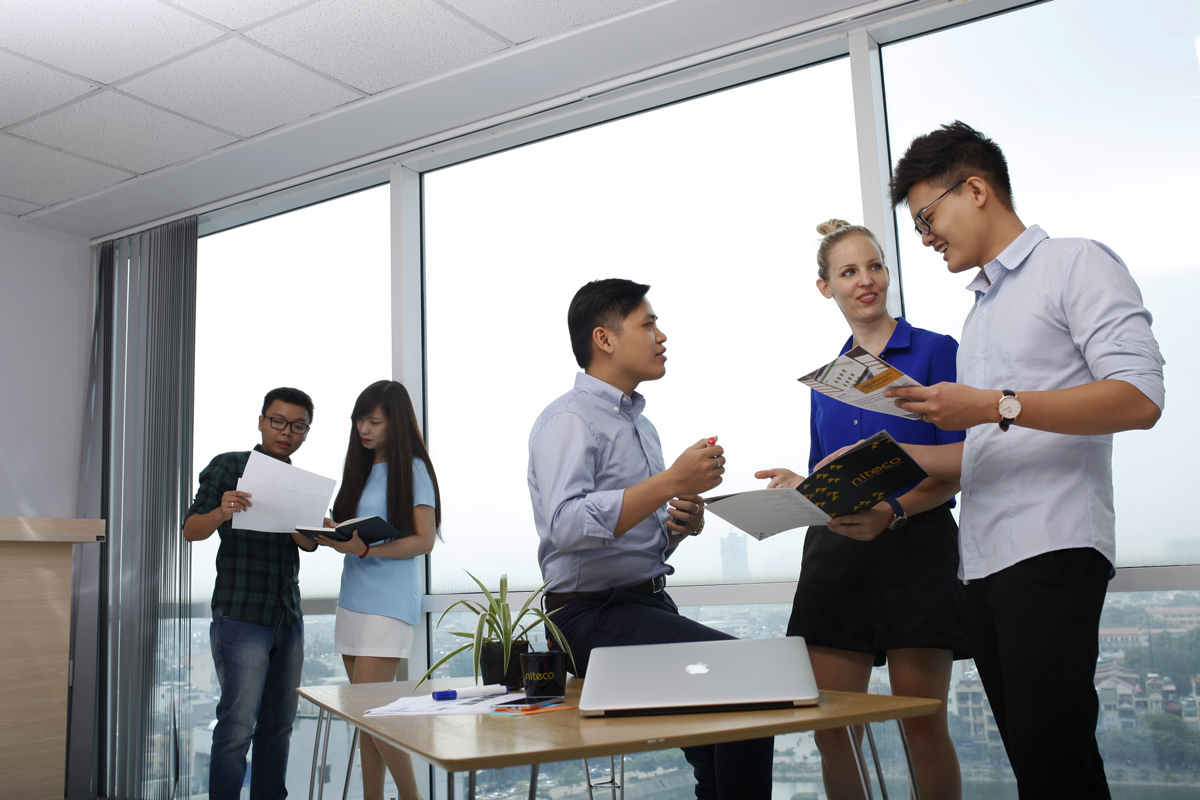 Team collaborating in a meeting room discussing business documents and ideas