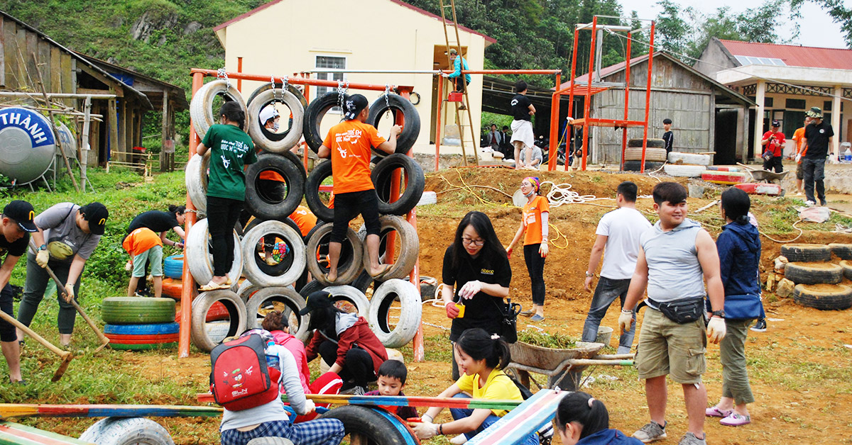 Youth team building activities outdoors with tire obstacle course and teamwork